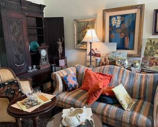 Looking into the entrance part of the living room. Vintage love seat, vintage cushions, highly carved cupboard, original art work