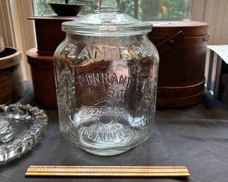L29 - $50. Vintage Planters Pennant Peanut Jar. General Store Glass Jar. Measures 8" wide x 12.5" tall. Has minor chipping around the rim of the inside of the jar.