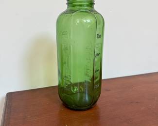 L52 - $10. Green Juice Bottle. Measures 3.5" wide x 9.25" tall.