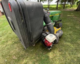 John Deere Riding Lawn Tractor with Honda-Powered Bagger System
John Deere riding mower with large rear bagger attachment and Honda engine-powered vacuum system. Heavy-duty setup for efficient lawn collection. Hampshire IL estate sale.