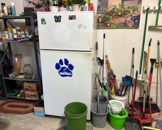 Various mops, brooms, refrigerator