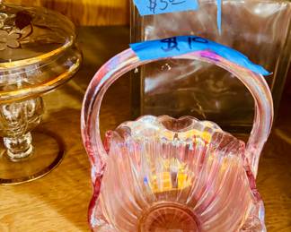  Small pink glass basket with an applied handle and ruffled edges. Opalescent shine in the light.