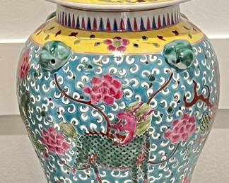 Striking hand-painted porcelain ginger jar featuring turquoise ground, floral scrollwork, and mythical Qilin motifs. Topped with a foo dog lid and detailed with figural elephant head handles. Vibrant Famille Rose palette with yellow collar and rich enamel detail. Made in Jingdezhen.
Approx. 17”H