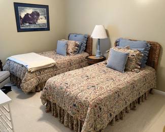 Twin beds w/ wicker headboards, wicker table, lamp