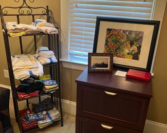 Linens, metal shelf, wooden file cabinet