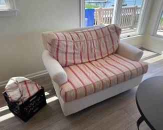 Upholstered loveseat glider with set of striped slipcovers