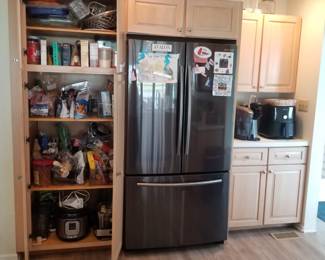 Kitchen cabinetry: Designer by Medallion. Pantry wall. Samsung refrigerator