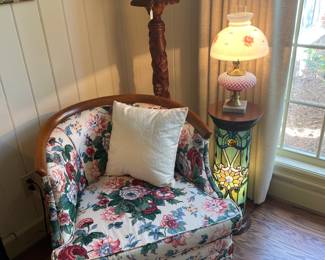 Floral upholstered armchair with carved mahogany pedestal and Weller vase