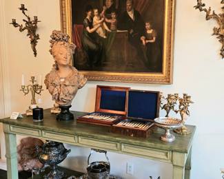Large painting of a German family. Unsigned. Bronze sconces, candlelabra, silver plated urn on lower shelf, plated wine chiller, exhibition terra cotta bust "Head of a Woman" by Carrier-Belluse, boxed fruit and fish sets. Tiffany & Co. reprosse compote.