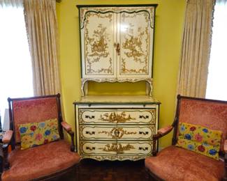 Chinoisoire style step back cabinet used as an entertainment center. Doors above. Drawers below are faux - they are actually doors. Pair of open arm chairs. Needlepoint pillows.