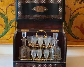 Napoleon III tantalus or wine cabinet. Two decanters in back are missing. One glass is missing. Folding top is in good working condition. Inlaid mother of pearl decoration is in good condition.