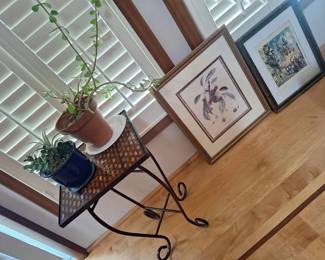 Interesting artwork and small side table with plants.