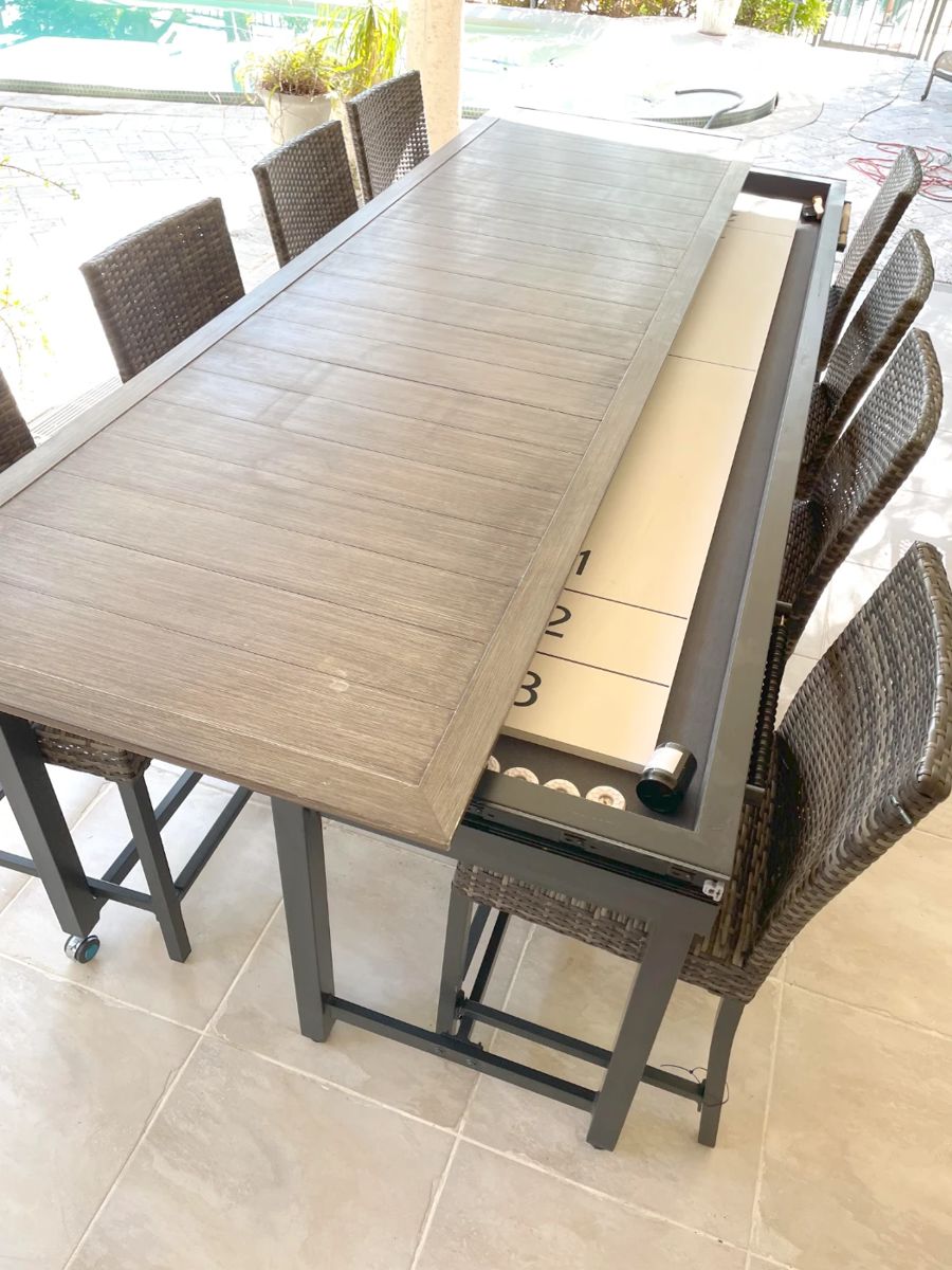 Home Decorators Collection outdoor convertible shuffleboard table with eight (8) chairs. The table can be closed for dining or open for play. Measures 9’9” long and 26” high. Open the table measures 56” wide and closed it measures 35” wide. It’s a super cool party piece for the outdoor living area.