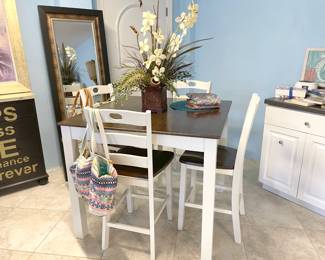 A white and natural wood hightop with 4 barstools.