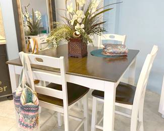 A white and natural wood hightop with 4 barstools.
