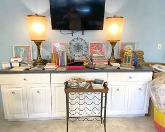 A pile of children's books, sweet little wine rack, and two retro lamps in the MCM style.