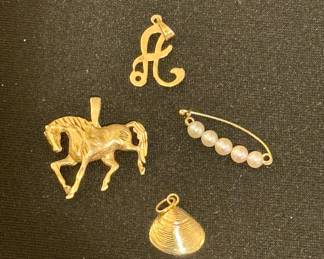 Gold charms ("A," horse, and shell)