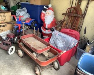 Two red metal wagons, snowblow Santa and reindeer, two older sleds, older metal tricycle, plastic tricycle, older peddle car