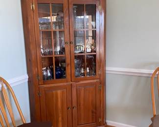 This beautiful traditional corner hutch features warm-toned wood construction with a classic two-section design, including glass-front display doors on top and solid wood cabinet doors below. The upper section allow you to showcase an impressive collection of glassware and stemware, while the lower cabinet provides enclosed storage. The piece is perfect for dining room display and storage $100
