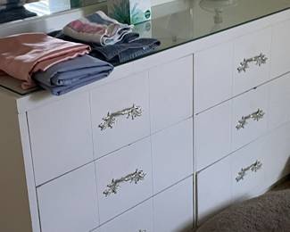 Bedroom set includes multiple coordinating pieces, all sold together for $400. Features clean lines and a with a white finish and glass top accents, perfect for creating a bright and airy look for a little girls room. Please note: while individual photos will be shown, all items are sold together as a complete set.