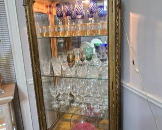 Beautiful glassware in an antique curio. Gold-trimmed vintage glasses by Culver, other stemware, both colorful and crystal