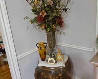 Side table with marble top, large floral arrangement and other home decor
