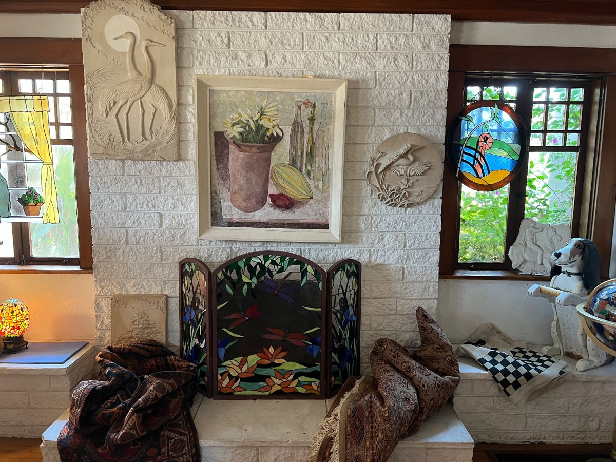 Vintage stain glass screen, hand carved beagle towel holder, sandstone wall sculptures (E. Engles),antique Karistan rug (72" x 98" ) and another antique rug (56" x 84").....Large painting by artist Jack Stangle 