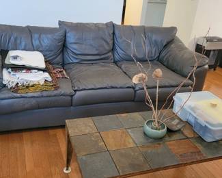 Leather sofa. Shows wear on arms and seats