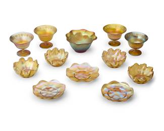2079
A group of Tiffany Studios Favrile glass table articles
Early 20th century
underplates and bowls each variously numbered and etched: L. C. T.; footed vessels etched: L. C. Tiffany / Favrile; one unmarked
Comprising four handkerchief bowls, three scallop-rimmed underplates, and four footed compotes with grapevine motifs to rim, together with an associated Favrile-style footed bowl
12 pieces
Each bowl: 2" H x 4.625" Dia.; Each compote: 3.5" H x 4.875" Dia.; Associated: 3.25" H x 6.375" Dia.
Estimate: $800 - $1,200