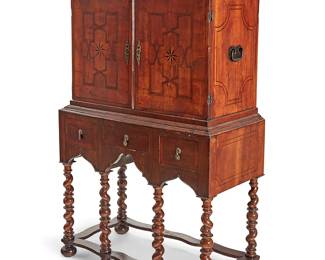 2268
A William & Mary walnut marquetry highboy cabinet
18th century
The cabinet surmounted by an architectural cornice over a two-door cupboard opening to reveal a fitted interior with ten drawers and one smaller cupboard containing three additional drawers, flanked by wrought iron bail handles, over three short drawers and a shaped apron, the doors and drawers with X-motif marquetry inlay, and raised on barley twist legs with bun feet joined by a shaped box stretcher
67.5" H x 40" W x 20" D
Estimate: $1,000 - $1,500