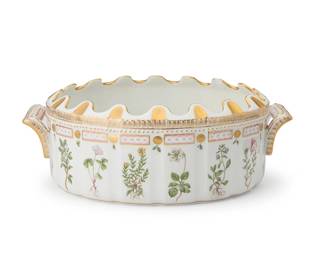 2432
A Royal Copenhagen porcelain 'Flora Danica' monteith
1969-1973
Marked to underside: Royal Copenhagen [with dot under 'G'] / [crown logo] / Denmark / 20 / 3531; further marked with three waves in blue underglaze
Designed 1790, the wine glass chiller with opposed handles and scalloped rim, hand-painted with gilt embellishments, depicting sixteen botanicals in registers and one to interior, each labeled at bisque underside in script
4.75" H x 13.25" W x 9.5" D
Estimate: $2,000 - $3,000