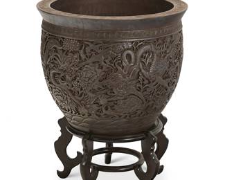 2344
A large Chinese silver-clad jardinière
20th century
Bearing Qianlong mark below rim
The silver-clad planter with a band of meandering motifs above a dragon and floral motif body, set on a wood stand
Jardinière: 18.5" H x 22.5" Dia.; Stand: 10.5" H x 18.5" Dia.
Estimate: $1,000 - $1,500