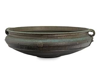 2373
A large Indian bronze temple bowl
Late 19th/early 20th century
One side bearing inscription
The cast bronze low bowl with rosette motifs and two loop handles
9.5" H x 28.25" Dia.
Estimate: $500 - $800