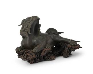 2347
A Japanese patinated bronze Shishi figure
20th century
The lion/dog guardian figure depicted recumbent and set into a carved burlwood stand
Overall: 10" H x 16.25" W x 9" D
Estimate: $300 - $500