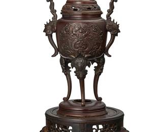 2204
A Japanese patinated bronze censer
Meiji period (1868-1912) or later
The lidded 'koro' censer with finial in the form of Kirin above opposed figural handles and the body depicting mythical beasts, raised on tripod legs joined on a circular base, set on a wood stand
Censer: 13" H x 7" W x 5.5" D; Stand: 3.5" H x 8" Dia.
Estimate: $700 - $900