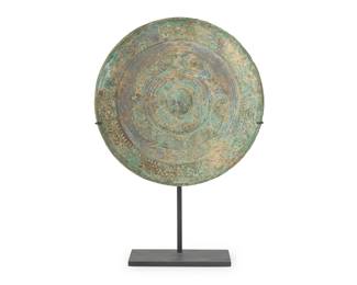 2321
A Chinese bronze mirror
Han Dynasty (206 BCE-220 CE) or style
The circular mirror cast with central knop surrounded by petal forms within a stylized scroll outer border, set in an enameled metal stand
Mirror: 8.25" Dia.; Overall: 11.625" H
Estimate: $1,200 - $1,800