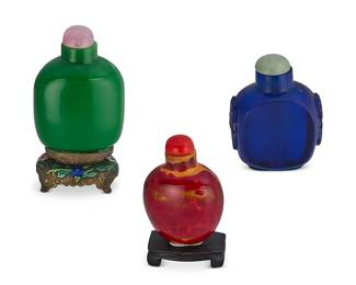 2150
Three Chinese glass snuff bottles
19th/early 20th century
Comprising a blue Peking glass bottle, a red and ochre glass bottle mounted on a wood stand, and a green glass bottle mounted on enameled silvered metal stand
3 pieces
Tallest: 3.75" H
Estimate: $400 - $600