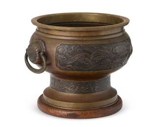 2353
An East Asian bronze jardinière
20th century
The footed planter cast with Koi amidst waves, with opposed lug handles, set on a wood base
9.25" H x 12" W x 10.75" D
Estimate: $300 - $500