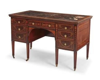 2417
An Edwardian marquetry kneehole desk
Attributed to James Phillips & Sons, Ltd., early 20th century
The tabletop with blind-stamped leather, above seven drawers with lion's head mask ring pulls, the front inlaid with bellflower swags and ribbons
30" H x 48.25" W x 25" D
Estimate: $700 - $900