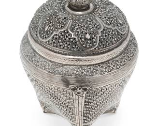 2287
A Southeast Asian sterling silver tea caddy
Late 19th/early 20th century; likely Indonesia
Appears unmarked
Possibly Yogya silver, the covered vessel with chased and repoussé basket weave motif and floral accents, the lid with elaborate pierced foliate scrolls
9.5" H x 6.5" Dia.
18.6 oz. troy approximately
Estimate: $400 - $600