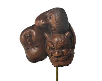 2206
A Japanese carved hardwood mask group okimono
19th century
The conjoined cluster of theatrical masks, recto including a monkey, a dragon, and a human face, verso including two human faces, mounted to a metal support and housed in a custom acrylic case
Masks: 1.75" H x 1.75" W x 0.875" D; Case: 7.5" H x 4.125" W x 3.75" D
Estimate: $500 - $700