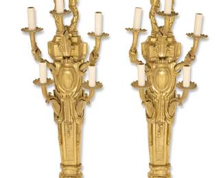2253
A pair of Louis XVI-style gilt-bronze wall sconces
20th century
Each five-light wall fixture with upper ribbons above an architectural standard issuing five arms with faux candle lights and foliate-form bobèches, electrified
2 pieces
Each: 39" H x 11.25" W x 7.5" D
Estimate: $500 - $700
