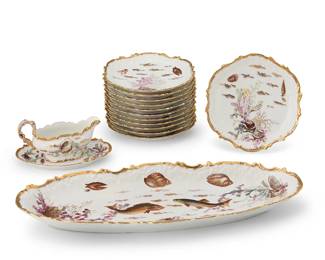 2411
A Limoges porcelain fish service
Early 20th century
Each twice marked to underside: Limoges / France
Each with transfer-printed sea life motifs and hand-gilt embellishments, comprising a serving platter (23.75" W x 9.75" D), a sauce boat (4.25" H x 7.375" W x 3.5" D) with underplate (8.875" W x 6.25" D), and twelve plates (9.375" Dia.)
15 pieces
Estimate: $300 - $500