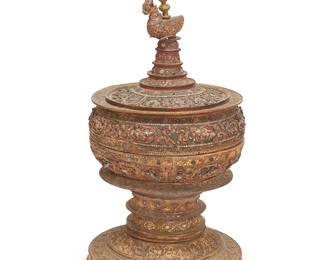 2292
A Burmese Hsun Ok offering jar
19th century or later
The footed and lidded carved wood bowl featuring a gilt and jeweled exterior profusely decorated with carved floral motifs, the interior lacquered, surmounted by a figural finial
40.5" H x 19.75" Dia.
Estimate: $300 - $500