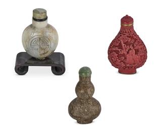 2145
Three Chinese snuff bottles
19th/20th century
Comprising a grey nephrite snuff bottle, a cinnabar snuff bottle, and a carved mottled stone double gourd snuff bottle
3 pieces
Tallest: 3" H
Estimate: $300 - $500