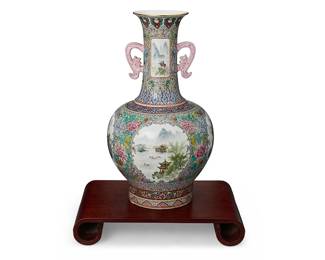 2179
A Chinese polychrome porcelain vase
Mid-20th century
With apocryphal Qianlong Period reign mark painted to underside
The vase with opposed figural handles, intricate millefleurs, and landscape decoration, set on a carved wood stand
Vase: 20.75" H x 11.5" Dia.; Stand: 3.125" H x 18" W x 11.5" D
Estimate: $1,200 - $1,500