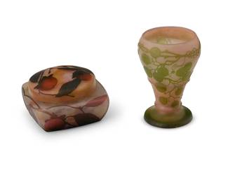 2089
A Gallé cameo glass vase and a Daum cameo glass box
Early 20th century; France
Vase signed in relief near base: Gallé; the box signed in relief: Daum Nancy / France with cross of Lorraine
The Gallé footed vase with green overlay depicting grape motifs on a pink frosted glass ground, and the Daum lidded box with polychrome overlay depicting fruit on a frosted clear glass ground
2 pieces
Gallé: 6.5" H x 4.5" Dia.; Daum: 3.75" H x 6" W x 6" D
Estimate: $500 - $800