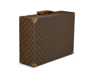 2103
A vintage Louis Vuitton Monogram 50 suitcase
Circa 1960s-1970s, France
Marked to exterior hardware, handle, and interior buckles for Louis Vuitton; Interior label: Louis Vuitton / 906922 / AVe Marceau 78 bis Paris / Nice. 2 AVe De Suede
A hard-sided suitcase No. 906922 with LV Monogram coated canvas in brown and tan with leather trim, a single square layered leather handle, branded brass hardware, brass corners, and interior branded straps
14.25" H x 19.75" W x 6.25" D (36 cm x 50 cm x 16 cm)
Estimate: $800 - $1,200