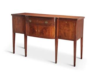 2401
A Hepplewhite-style mahogany bow front sideboard
19th century
The wood sideboard with inlaid veneer trimming and bellflower motifs to fronts, featuring a central locking drawer above two locking hinged cabinet doors revealing an open cavity, flanked by locking cabinet doors, raised on attenuated square legs
40.75" H x 68" W x 28.25" D
Estimate: $500 - $800