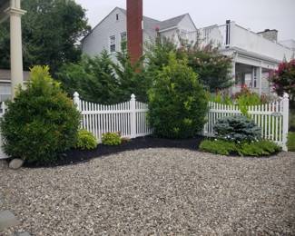 Vinyl fencing; shrubbery. Gravel sold by the 5-gallon bucket